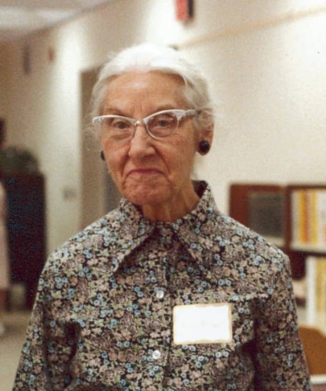 Helen Munsel in a flowery dress and long white hair.